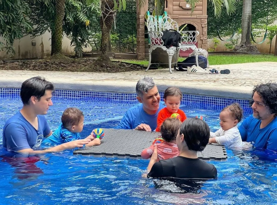 Familias reunidas en una piscina residencial durante una clase al aire libre