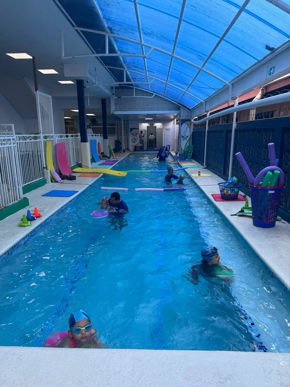 Piscina techada de la sede San Francisco durante una clase, con alumnos e instructor en el agua